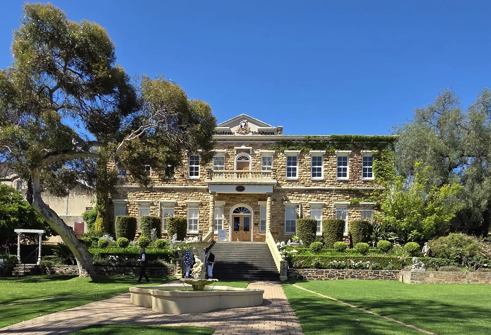 Historic stone mansion with spring gardens and a gum tree in the Barossa Valley
